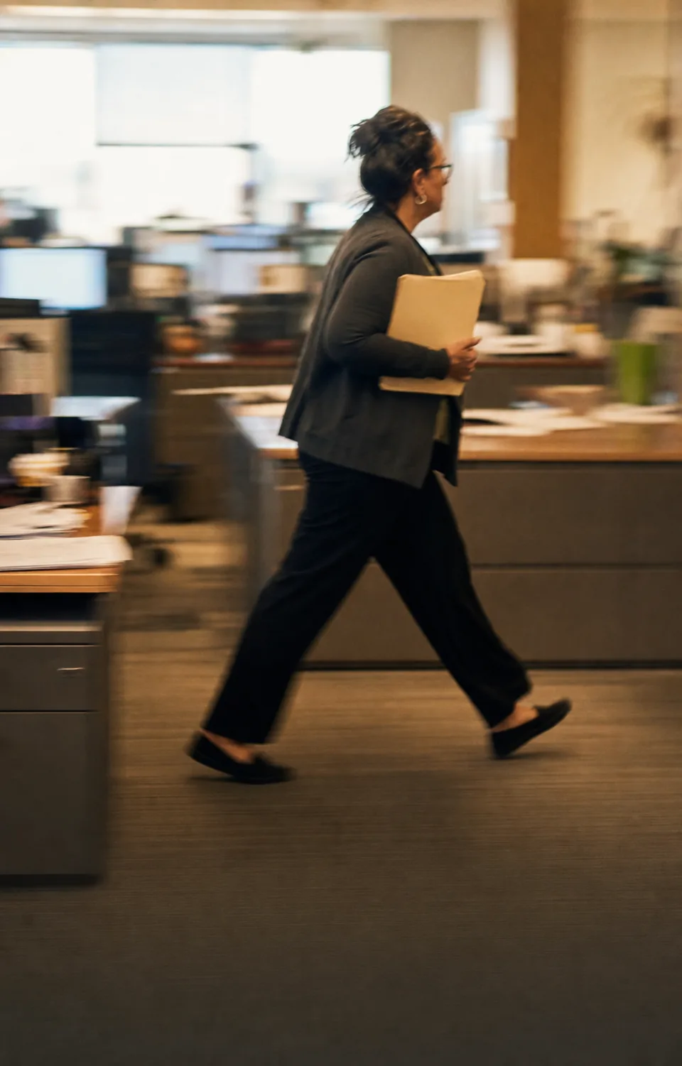 Motion-blurred hospital administrator moving quickly through a busy back office